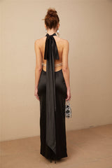 A black satin maxi dress with a halterneck style featuring faux pearl embellishments
