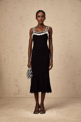 A black sleeveless midi dress with a crochet knit pattern throughout the garment