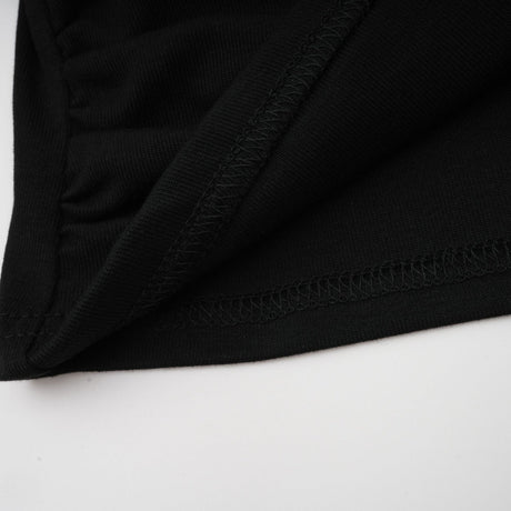 A black sleeveless top with an open front and gathered fabric details