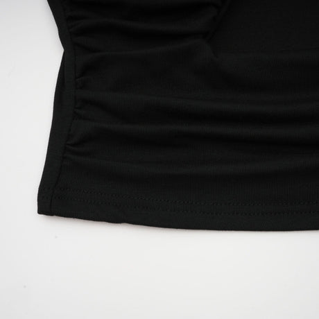 A black sleeveless top with an open front design and gathered fabric detailing