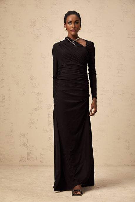 A black tulle maxi dress with asymmetric design and cutout details worn by a model named Natalie