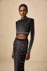 A black twopiece outfit consisting of a mesh top and skirt adorned with rhinestones The set features a sleeveless top and a fitted skirt both embellished with sparkling details for a glamorous look