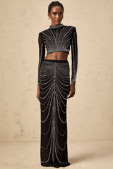 A black twopiece outfit consisting of a mesh top and skirt adorned with rhinestones The top is sleeveless with a high neckline The skirt is short and fitted Both pieces feature a sheer mesh material with sparkling rhinestone embellishments throughout