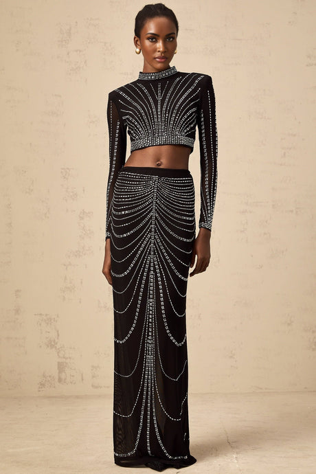 A black twopiece outfit consisting of a mesh top and skirt adorned with rhinestones The top is sleeveless with a high neckline The skirt is short and fitted Both pieces feature a sheer mesh material with sparkling rhinestone embellishments throughout
