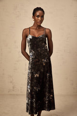 A black velvet midi dress with a butterfly print pattern featuring a fitted bodice and flared skirt