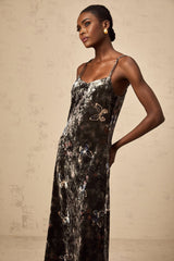 A black velvet midi dress with a butterfly print pattern featuring a fitted silhouette and long sleeves