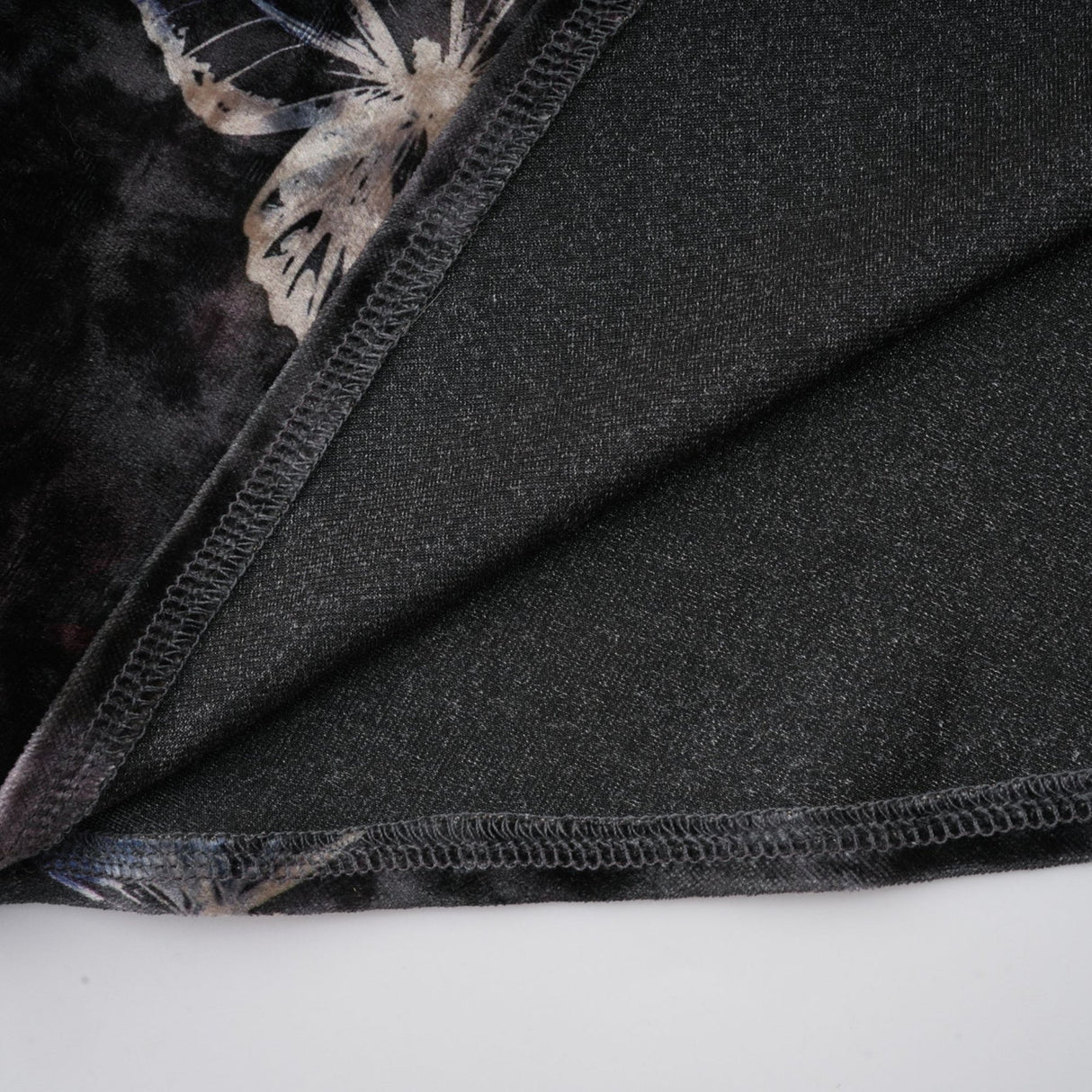A black velvet midi dress with a butterfly print pattern named Blanche on a plain background