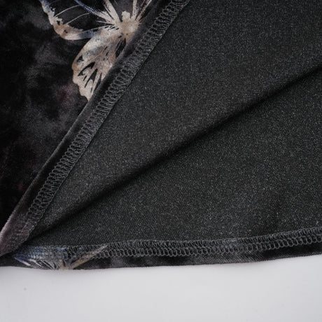 A black velvet midi dress with a butterfly print pattern named Blanche on a plain background