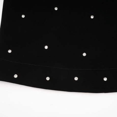 A black velvet midi dress with embellishments named Lola worn by a model against a plain background