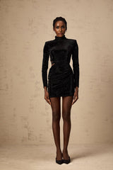 A black velvet mini dress with cut out details and stud embellishments featuring a sleek design and short length