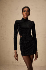 A black velvet mini dress with cutout details and stud embellishments designed by Yvette
