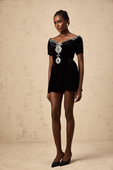 A black velvet mini dress with embellishments named Camille featuring a short hemline and decorative details