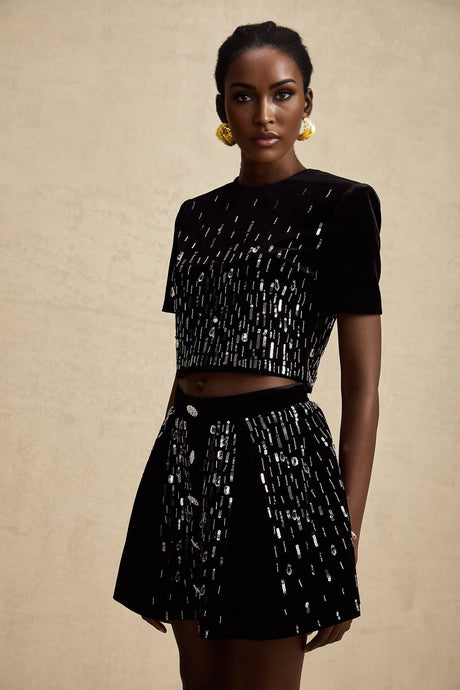 A black velvet two piece outfit consisting of a top and skirt set with embellishments called Isabeau The top and skirt are matching and feature decorative details on the fabric