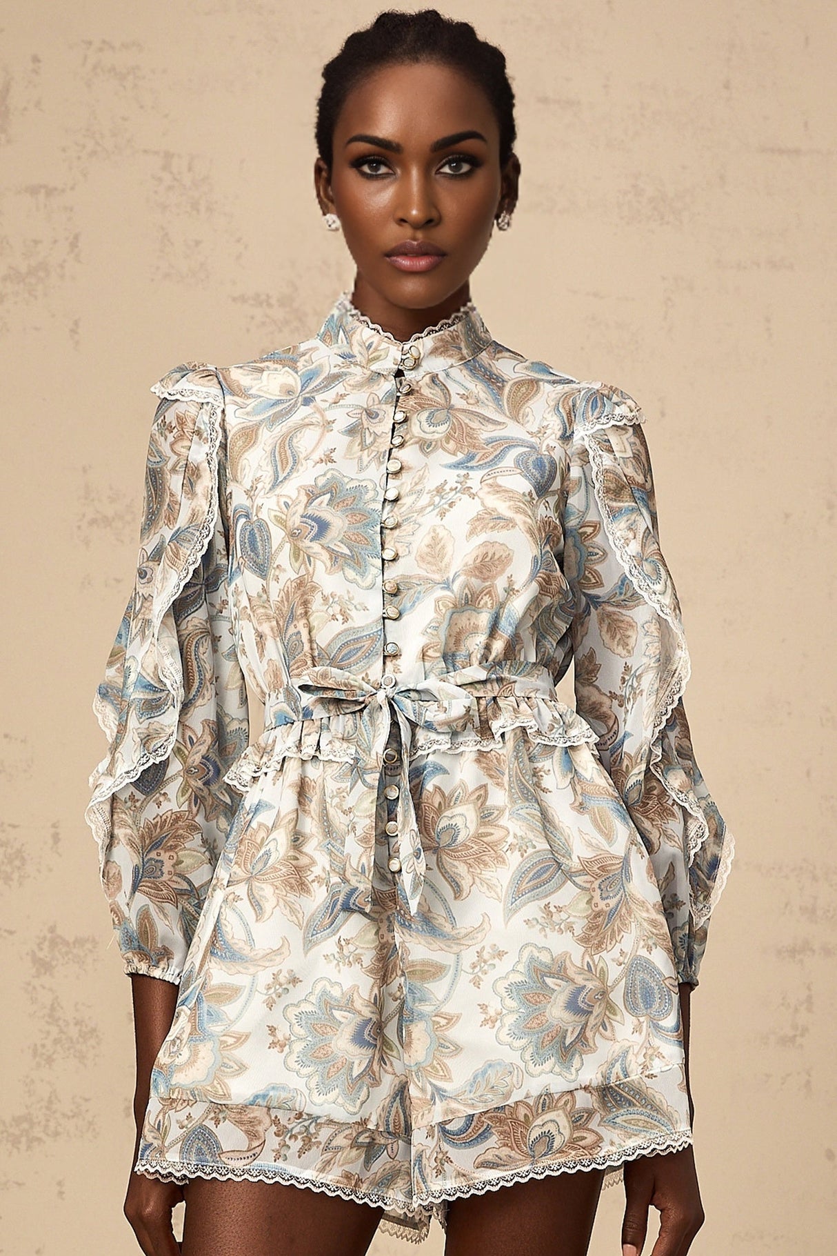 A blue floral print jumpsuit with ruffles and lace trim details named Eugenie