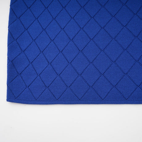 A blue knitted matching set consisting of a top and skirt The top features button details and the outfit is styled as a coordinated ensemble