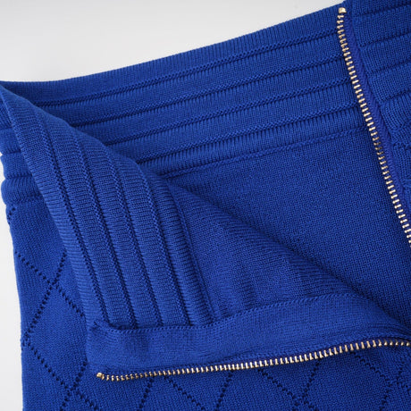 A blue knitted matching set featuring a top and skirt with button details The top has a fitted silhouette while the skirt is flared Both pieces are made from a textured knit fabric in a vibrant blue color