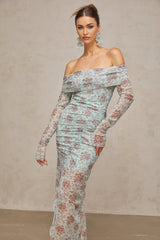 A blue maxi dress with a floral print pattern and ruched detailing by Honorine