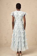 A blue midi dress with ruffles and small dot details named Corinna