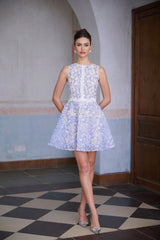 A blue mini dress with crochet lace detailing and puff sleeves featuring a fitted bodice and short flared skirt