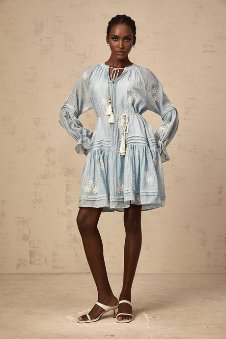A blue mini dress with delicate flower embroidery covering the fabric featuring a feminine and playful design