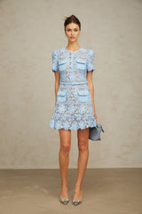 A blue mini dress with floral applique and ruffled lace details featuring a feminine and whimsical design