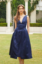 A blue satin midi dress with twist detail at the waist featuring a sleek silhouette and shiny fabric