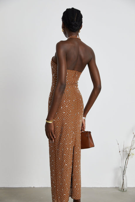 A brown long maxi dress with decorative details featuring a halter neckline and figure hugging silhouette