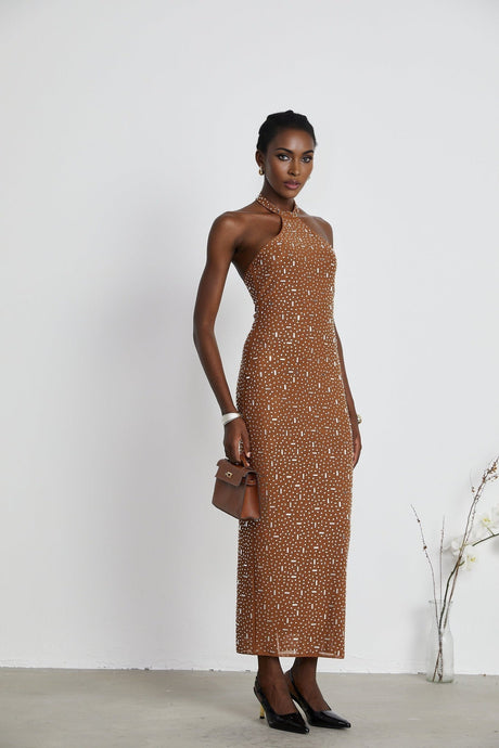 A brown long neckholder maxidress with decorative details and a figurehugging silhouette
