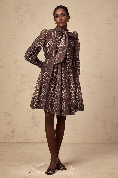 A brown mini dress with leopard print pattern featuring a large bowknot detail and a xylene inspired design