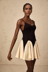 A colorblocked mini dress with godet pleated skirt featuring contrasting panels and a short hemline