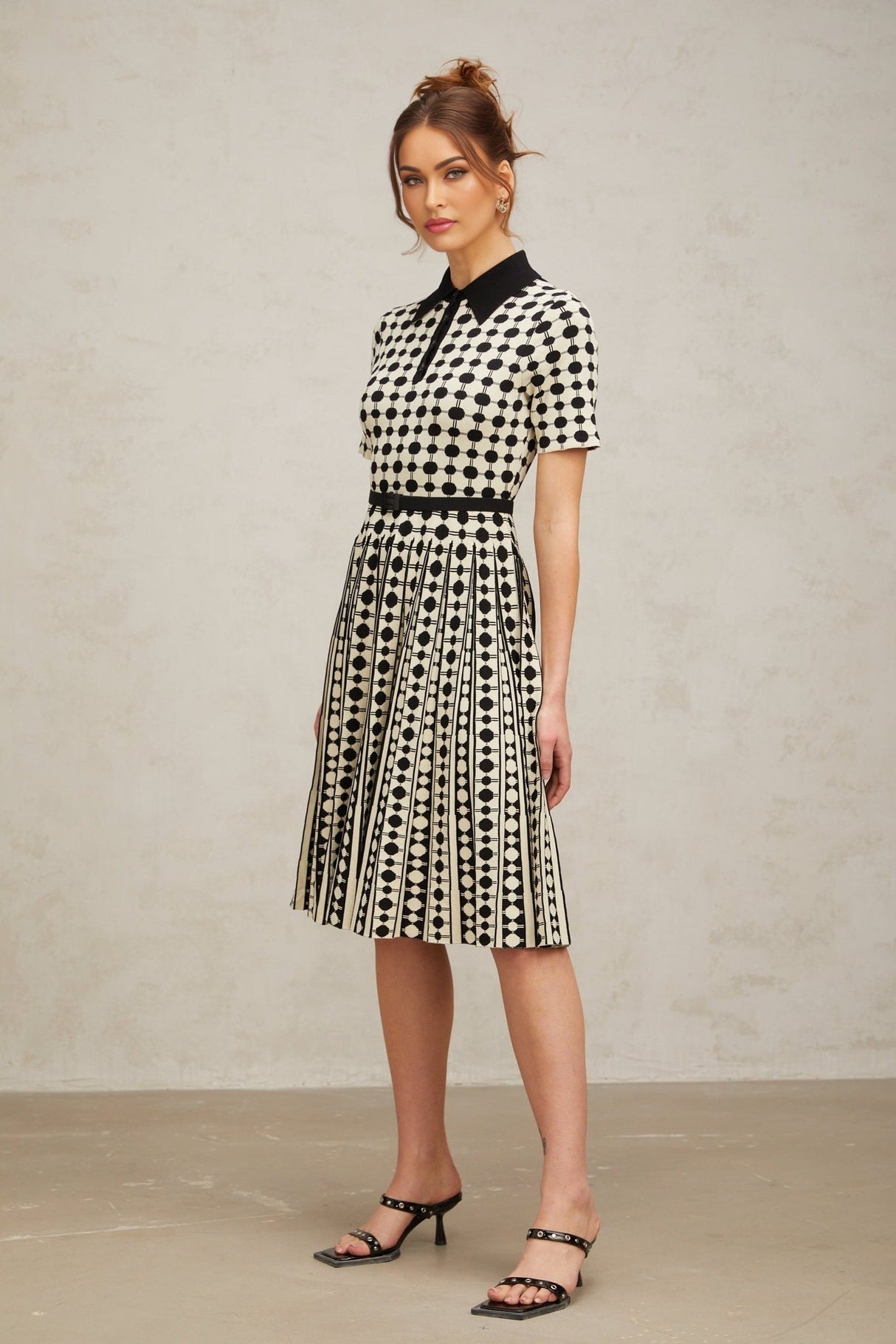 A colorful knit midi dress with polka dot pattern and color block design featuring different sections in contrasting colors