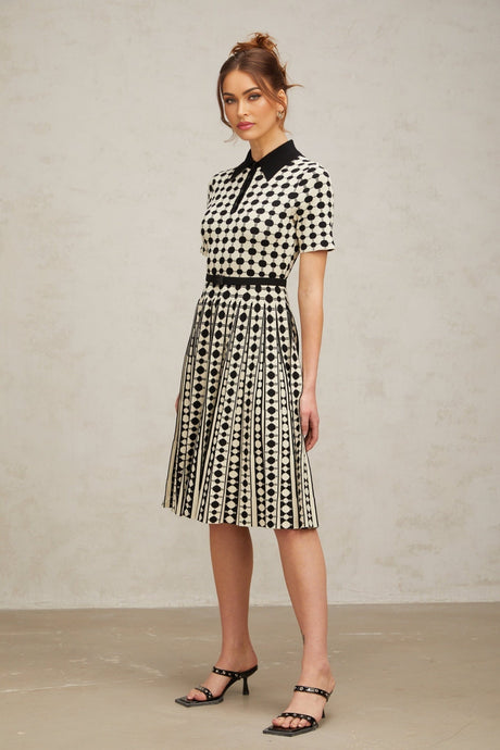 A colorful knit midi dress with polka dot pattern and color block design featuring different sections in contrasting colors