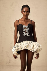 A colorful mini dress with a bow detail featuring color blocking and polka dot patterns