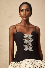 A colorful mini dress with polka dot pattern featuring color blocking and a decorative bow detail