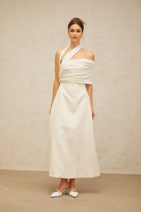 A creamwhite asymmetric maxi dress with one shoulder strap and a flowing skirt featuring a side slit
