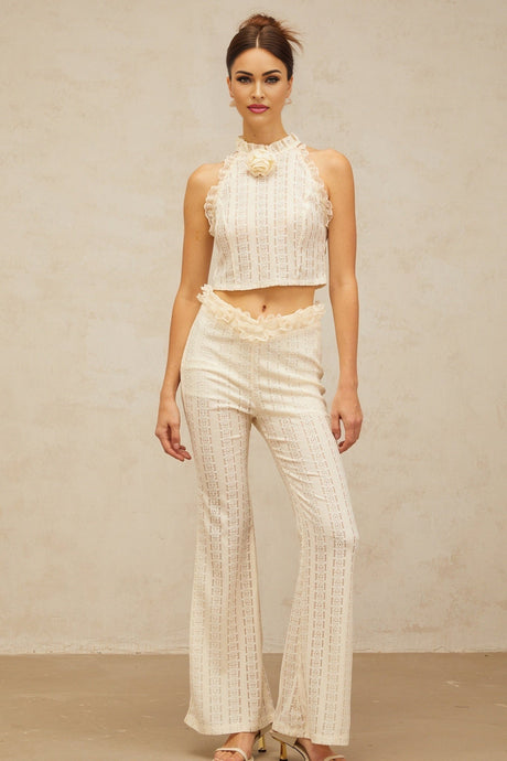 A creamwhite matching set consisting of a top and trousers The top features ruffled lace trim and a jacquard pattern The trousers match the top in color and fabric Both pieces are part of the Magali collection