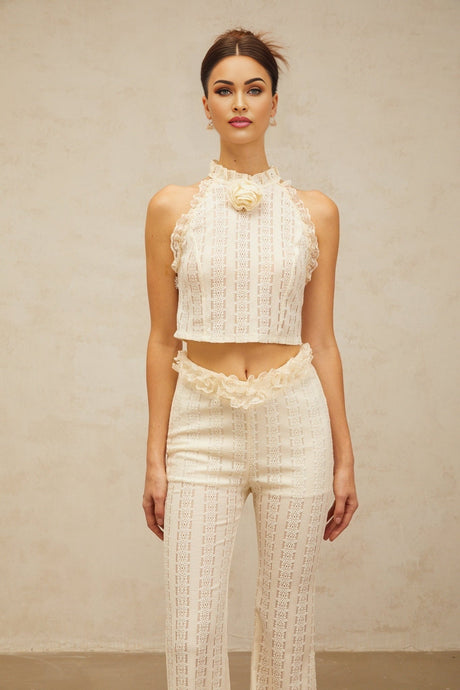 A creamwhite matching set featuring a jacquard top with ruffled lace trim and coordinating trousers both made in a textured fabric