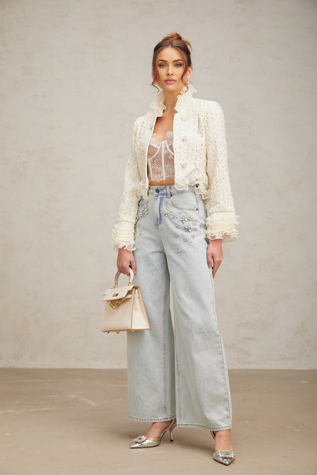 A cropped white jacket with beaded embellishments and ruffle details along the edges named Blanche