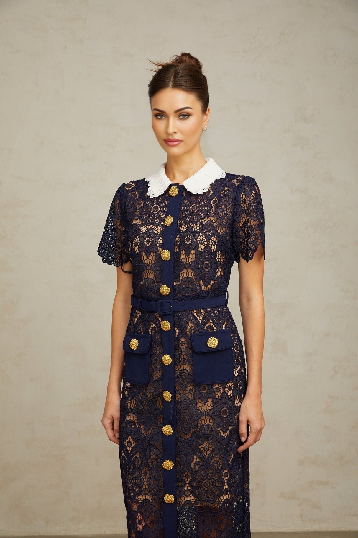 A dark blue midi dress with a floral crochet lace pattern covering the entire garment