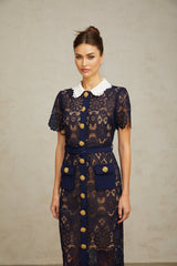 A dark blue midi dress with a floral crochet lace pattern covering the entire garment
