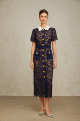 A dark blue midi dress with floral crochet lace patterns covering the entire garment The dress features a fitted silhouette and delicate lace detailing throughout