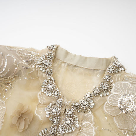 A delicate semisheer jacket made of organza fabric with floral beaded embellishments creating a light and luxurious appearance