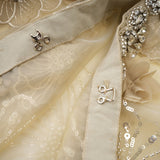A delicate sheer jacket with floral beaded embellishments on organza fabric creating a luxurious and lightweight appearance