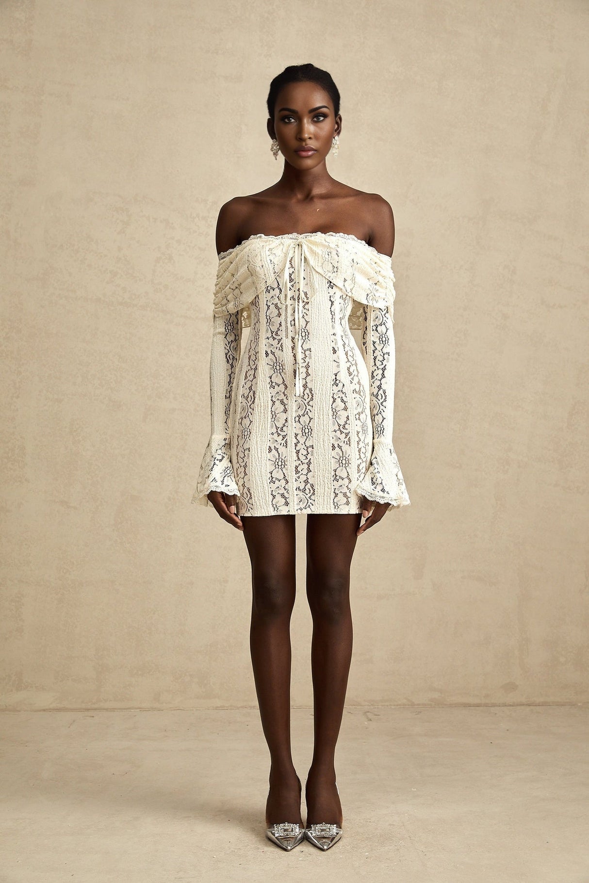 A feminine floral lace mini dress in neutral tones with flared cuffs named Emeline