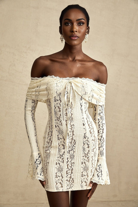 A feminine mini dress in neutral tones with floral lace detailing and flared cuffs named Émeline