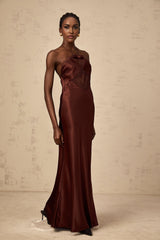 A floorlength winered satin dress with lace panels elegant long sleeves and a fitted silhouette