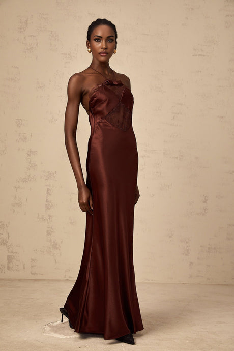 A floorlength winered satin dress with lace panels elegant long sleeves and a fitted silhouette