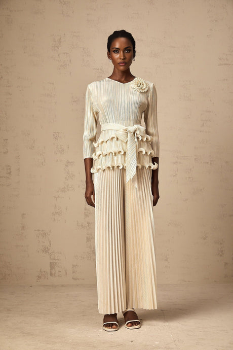 A floral jumpsuit with ruffles and pleats featuring applique flowers and a feminine silhouette