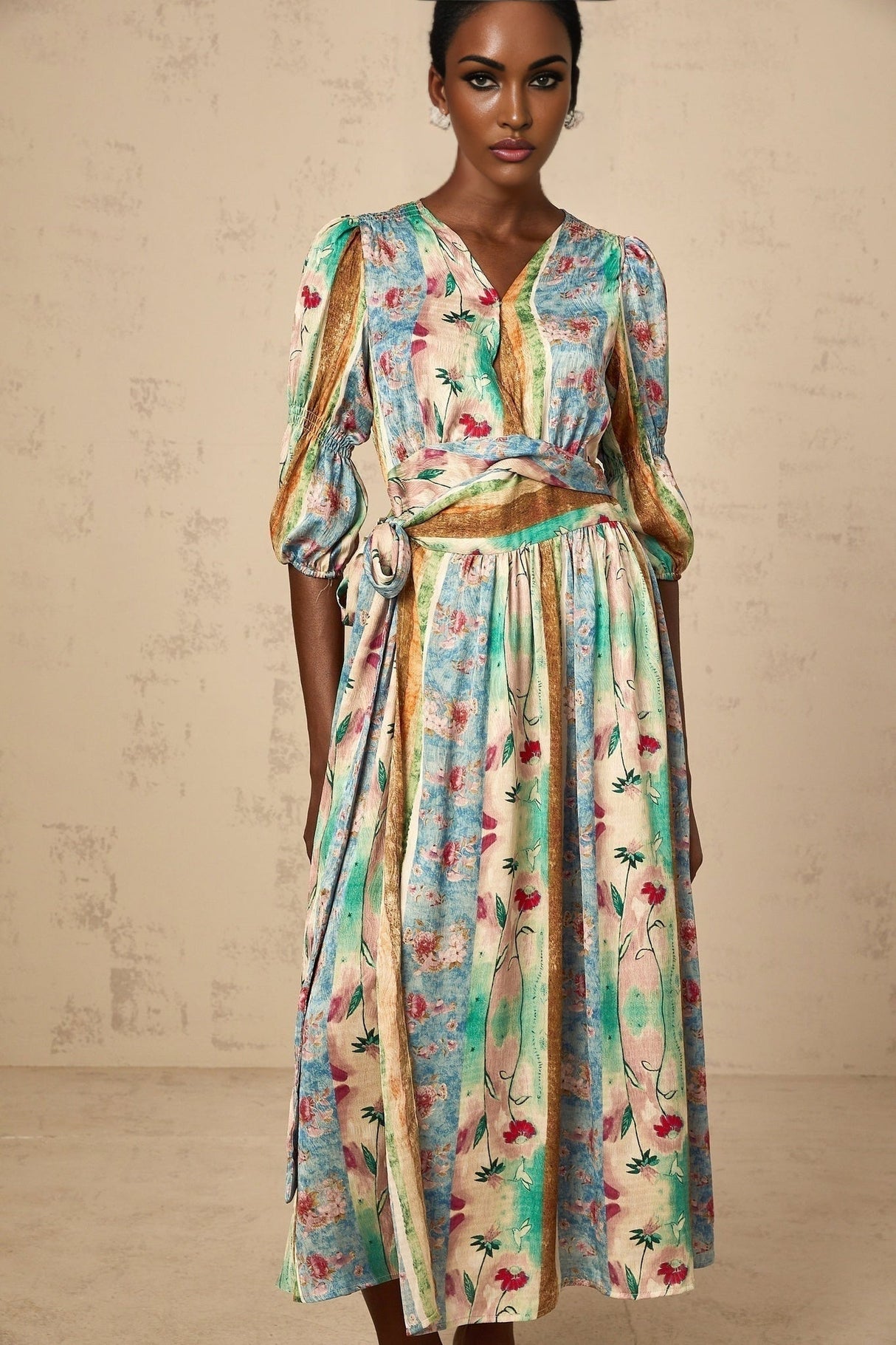 A floral midi dress in a vibrant cerise color with a wrap style design featuring a bold flower print pattern