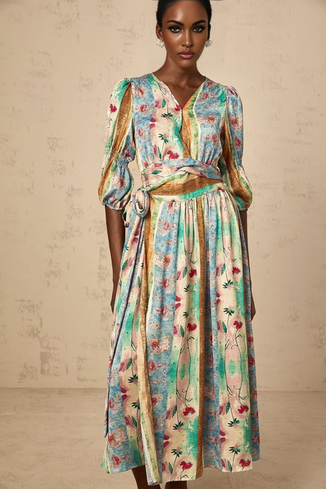 A floral midi dress in a vibrant cerise color with a wrap style design featuring a bold flower print pattern